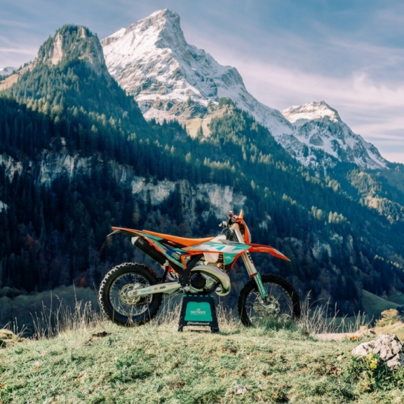 Moto d’enduro KTM posée en montagne avec paysage alpin en arrière-plan