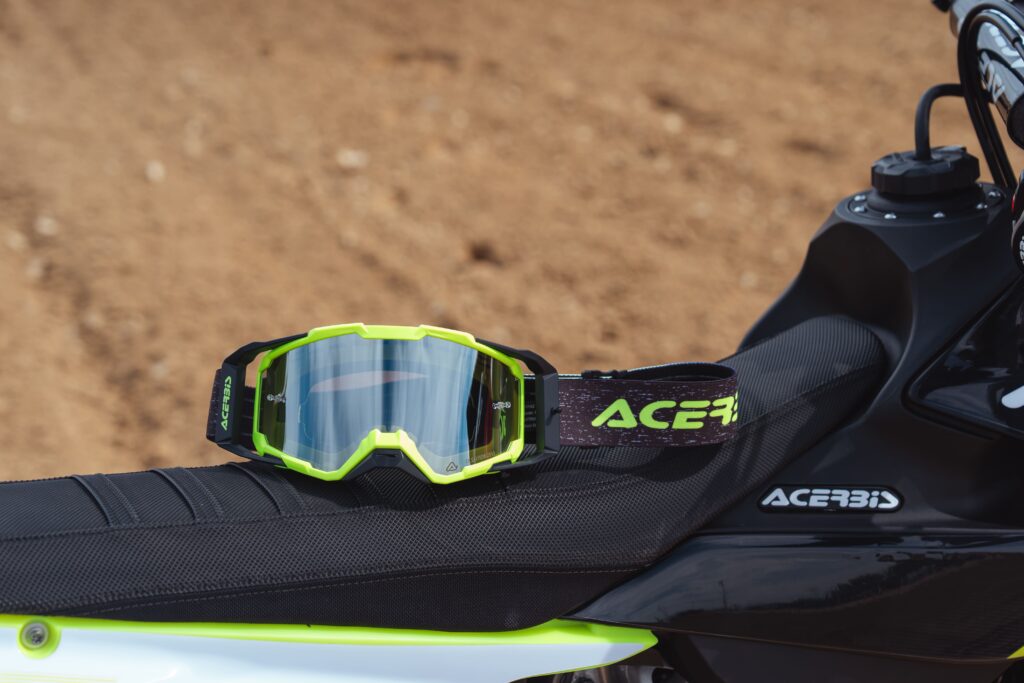 Masque Acerbis Vitrion coloris jaune fluo posé sur la selle d'une moto tout-terrain