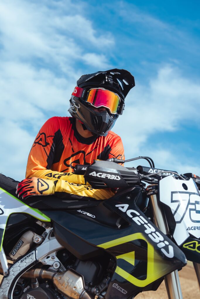Pilote tout-terrain équipé du masque Acerbis Vulcan lentille miroir sur moto de compétition