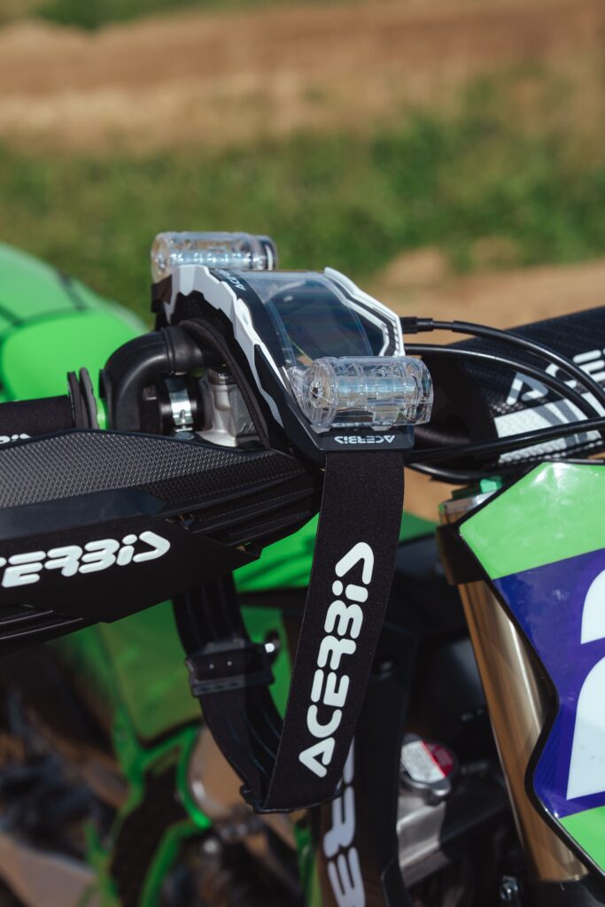 Pilote tout-terrain équipé du masque Acerbis Vulcan lentille miroir sur moto de compétition